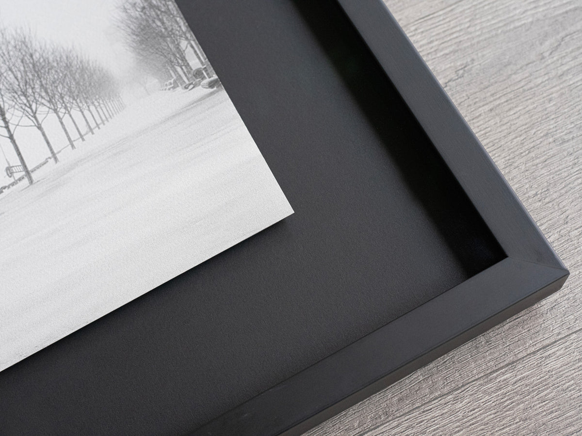 Close-up of a print recessed inside a black shadow box frame.