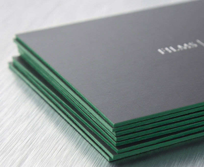 Load image into Gallery viewer, Stack of black business cards with vivid green-painted edges and a small silver wordmark.