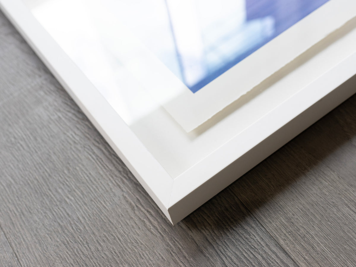 Close-up of a white shadow box corner with a deckled-edge print inside.