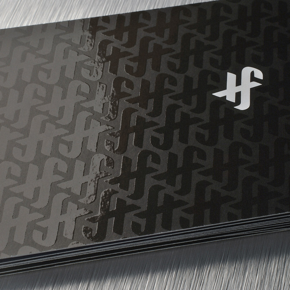 Black business cards with a raised clear gloss pattern, showing the transition between reflected light and matte areas.